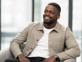 Daniel Kaluuya smiling during a seated interview, wearing a tan overshirt..
