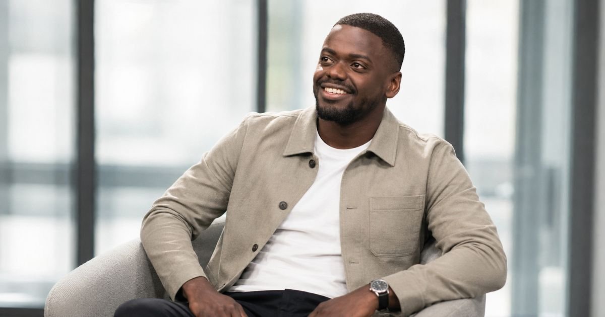 Daniel Kaluuya smiling during a seated interview, wearing a tan overshirt..
