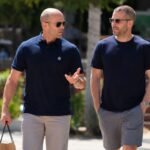 Hollywood actor Jason Statham walking and talking alongside a man in a casual outdoor setting.