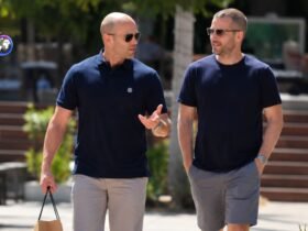 Hollywood actor Jason Statham walking and talking alongside a man in a casual outdoor setting.