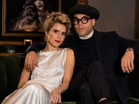 British singer Paloma Faith and French visual artist Leyman Lahcine sitting together on a dark green velvet sofa.