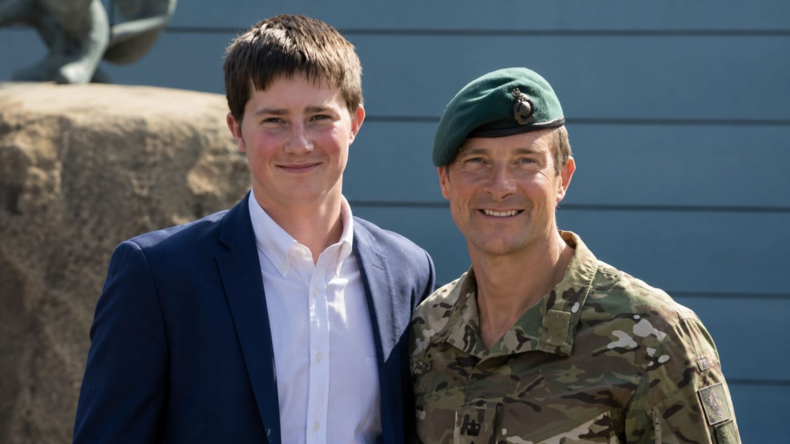 Marmaduke Grylls posing next to his father, Bear Grylls, who is dressed in military camouflage.