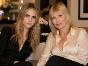 Cara Delevingne and her mother Pandora Delevingne sitting together on a sofa.